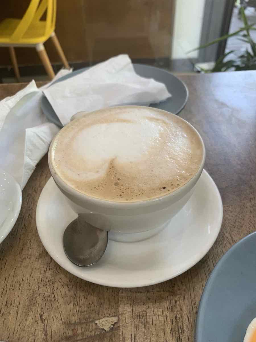 Cappuccino with foamed milk in a white cup on a saucer