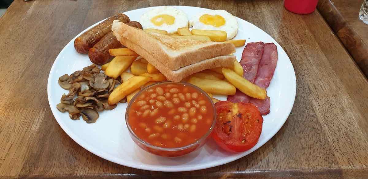 Full English breakfast with sausages, beef bacon, fried eggs, chips and beans