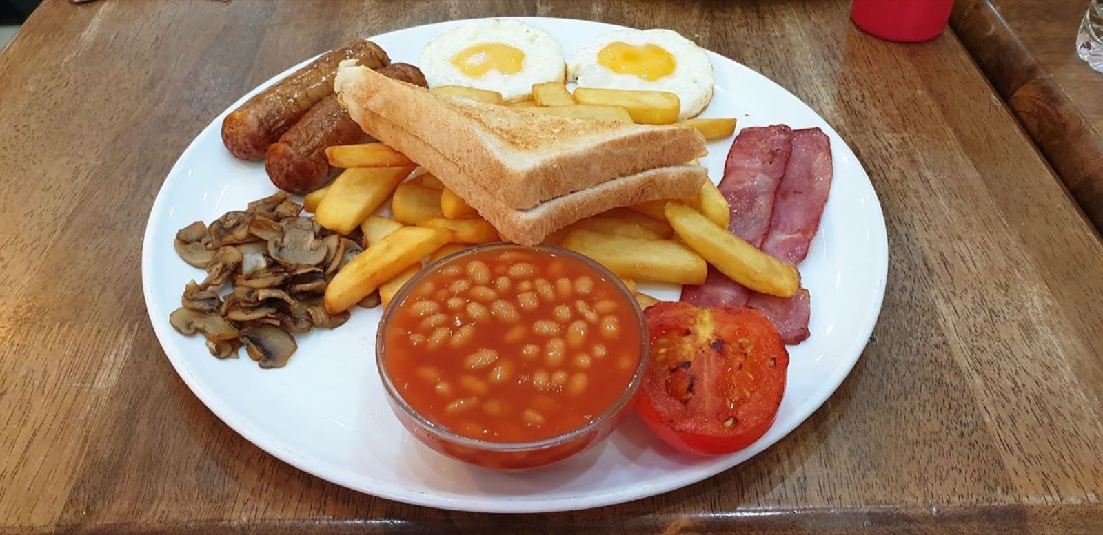 Full English breakfast at Delizia: fried eggs, sausages, beef bacon, chips, mushrooms, grilled tomato, baked beans and toast